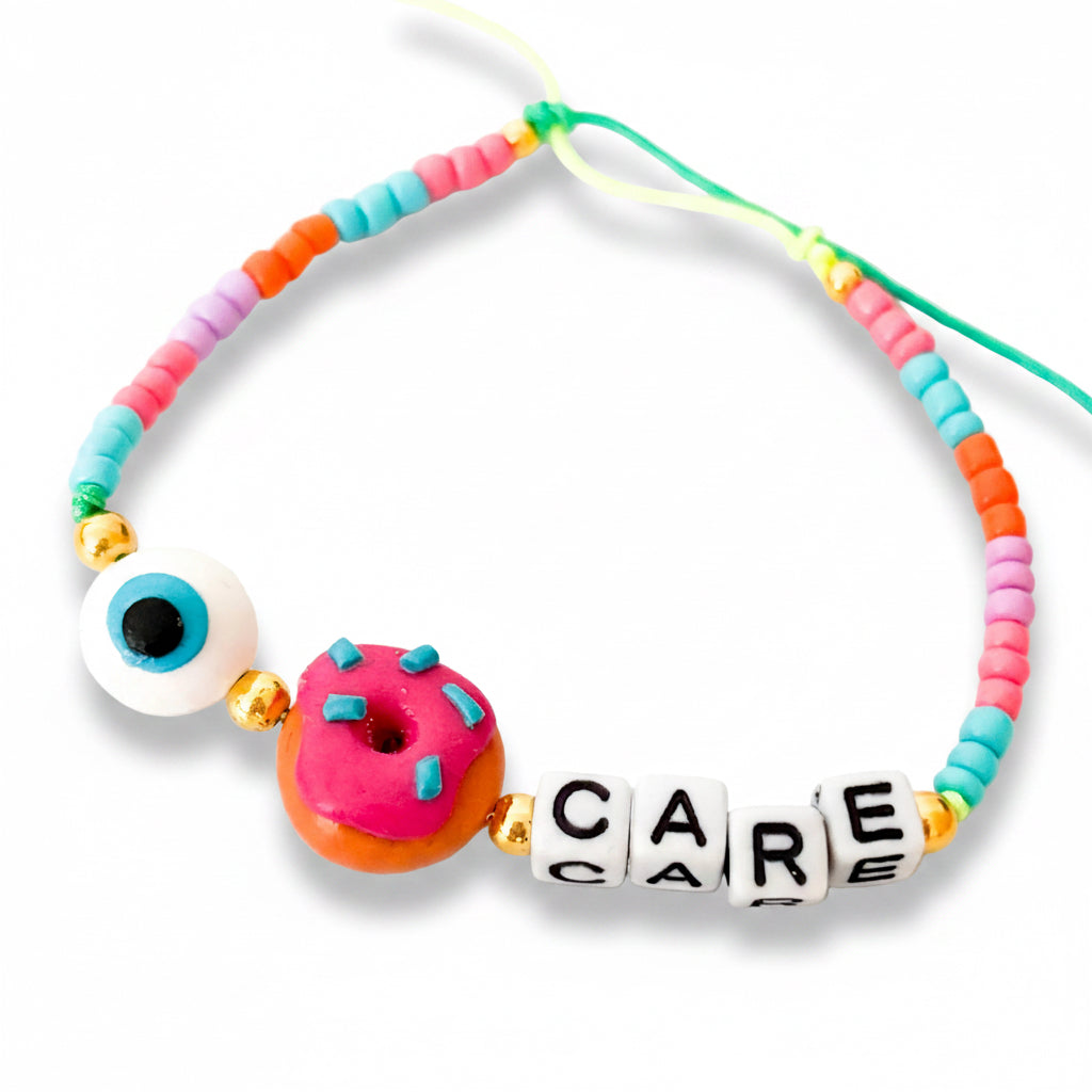 Colorful beaded necklace with a donut charm and 'CARE' beads on a white background